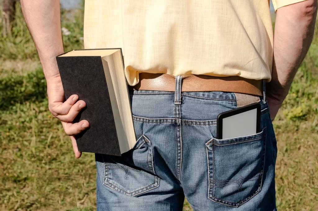 ズボンの後ろポケットに分厚い本を入れようとしている人